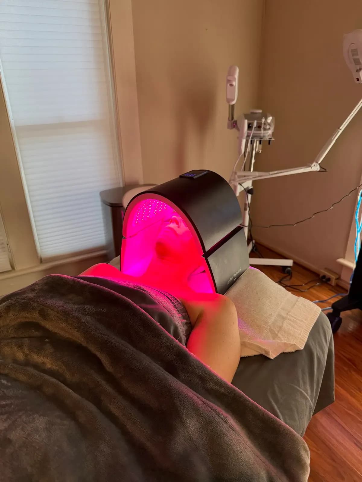A patient receiving red-light therapy during a facial